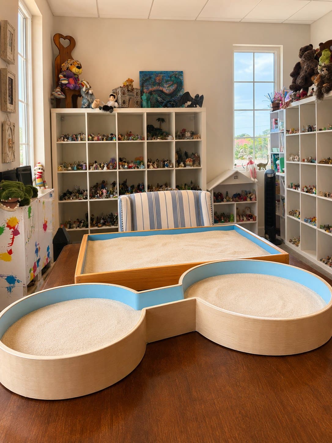 Dr. Parsons' play therapy room in Delray Beach, featuring the custom dog bone sand tray and shelves of figurines used in sand tray therapy.